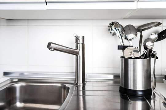 Sink and a metal container full of silver tableware
