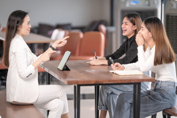 College instructors and advisors meet female college students to advise their research study....