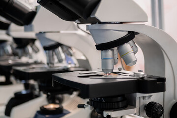 Professional medical microscopes with objective lenses in row in science lab, exhibition. Medicine, technology, laboratory concept