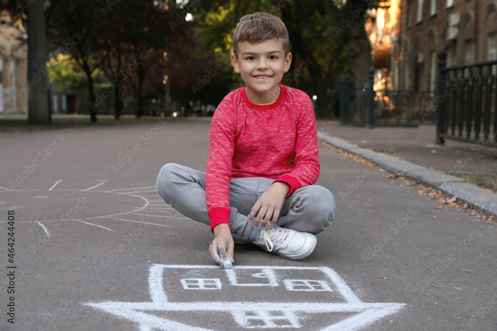 Poster Child drawing house with chalk on asphalt