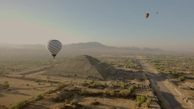 Beautiful aerial view of Pyramid of the Sun with sunrise and air balloons in  Teotihuacan, Mexico.