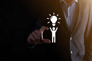 Businessman hold man icon with light bulbs, ideas of new ideas with innovative technology and creativity. concept creativity with bulbs that shine glitter.