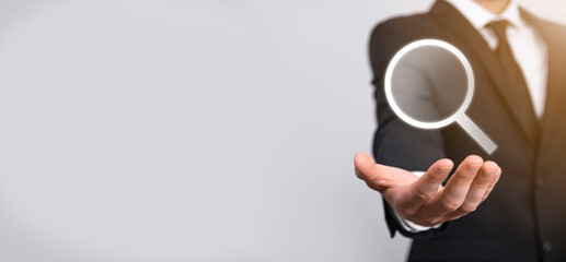 Male hand holding magnifying glass ,search icon on blue background. Concept search engine optimization, customer support.Browsing Internet Data Information.Networking Concept.