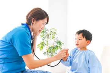 子どもを診察する若い看護師