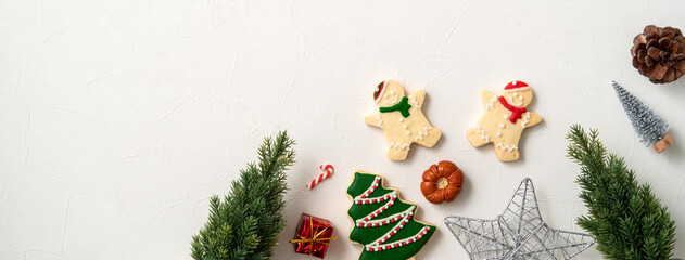 Decorated Christmas gingerbread cookies with decorations on white table background.