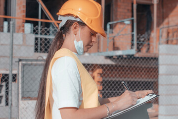 Mujer ingeniera trabajadora de la constructora de una inmobiliaria revisando objetivos y planos de...