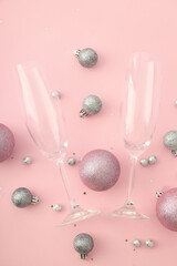 Champagne glasses and baubles on pink background