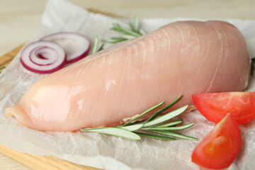 Concept of tasty food with raw chicken fillet on wooden background