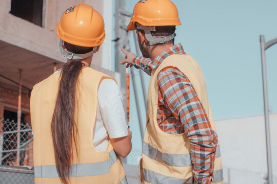 Joven equipo de constructores de arquitectura e ingenier&iacute;a realizando trabajos de obra y se&ntilde;alando la estructura del edificio para realizar las maquetas y objetivos de construcci&oacute;n