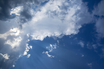Ciel bleu profond d'été nuageux et ensoleillé. Volutes blanches et grises dans la lumière estivale du Sud de la France
