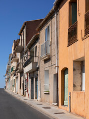Fototapeta na wymiar Ruelle d'une vieille ville du Sud de la France aux maisons colorées et anciennes avec balcons étroits. Rue montant vers les hauteurs de Sète.