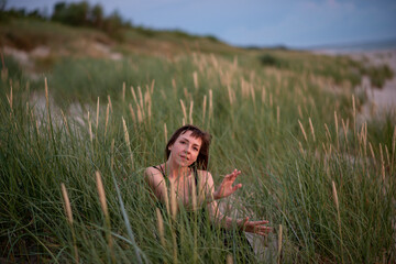 Woman sitting in the grass at sunset