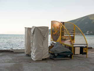 Electronic slot machines covered with textile on cement beach with mountain and sea on background...