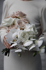 Beautiful bouquet of different flowers, close-up. Stylish modern bouquet, on a dark background.