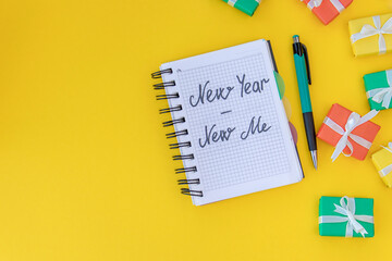 top view on Christmas background. notebook with the inscription new year - new me on a yellow...