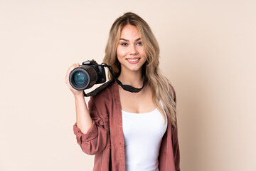 Young photographer girl over isolated background laughing