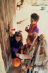 Kids in Halloween costumes near door during game