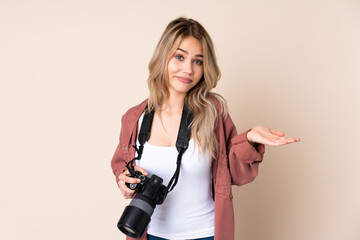 Young photographer girl over isolated background making doubts gesture