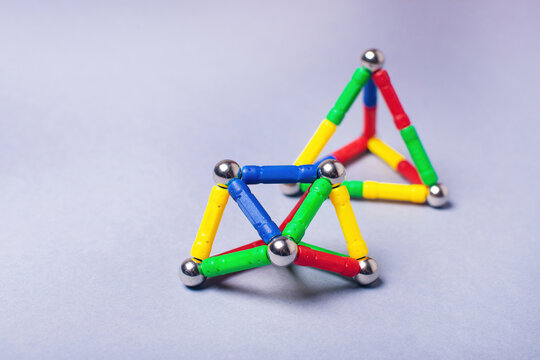 Bright magnetic constructor for children: creating shapes from sticks and balls. Development and logic.
