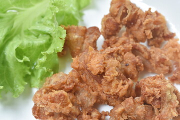 deep fried crispy salty chicken meat and skin on plate eat couple fresh lettuce vegetable salad