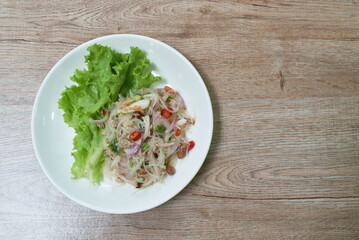 spicy glass noodles with chop pork and onion Thai salad on plate
