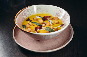 Tasty pumpkin cream soup with prawns and croutons.