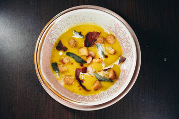 Tasty pumpkin cream soup with prawns and croutons.