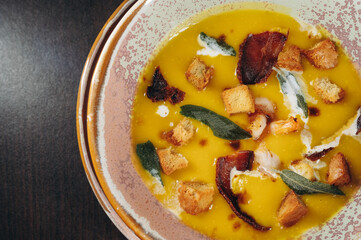 Tasty pumpkin cream soup with prawns and croutons.