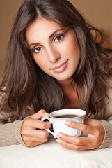 Coffee. Beautiful Girl Drinking Tea or Coffee. Cup of Hot Beverage. Young pretty woman drinking coffee. Morning.