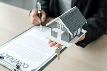 Agents working in real estate investment Hold the key and house Ready home insurance signing contracts in accordance with the home buying insurance agreements approving purchases for clients