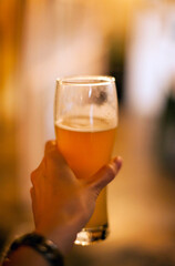 person holding a glass of beer at the bar close up