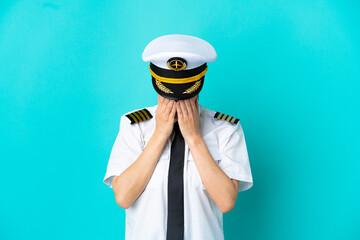 Airplane pilot caucasian woman isolated on blue background with tired and sick expression