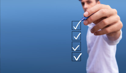 Young man checking 4 boxes with list of options on blue background