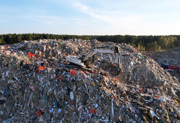 Obraz premium Landfill with Construction and Demolition waste (CDW). Trash disposal for recycling and re-use. Excavator working on industrial landfill. Recycling of building waste materials. Secondary raw.