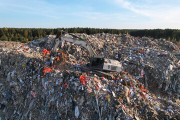 Landfill with Construction and Demolition waste (CDW). Trash disposal for recycling and re-use. Excavator working on industrial landfill. Recycling of building waste materials. Secondary raw.