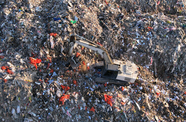 Obraz premium Landfill with Construction and Demolition waste (CDW). Trash disposal for recycling and re-use. Excavator working on industrial landfill. Recycling of building waste materials. Secondary raw.