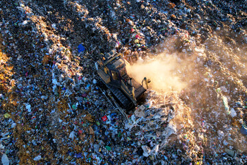 Landfill waste disposal. Garbage dump with waste plastic and polyethylene. Bulldozer at landfill...