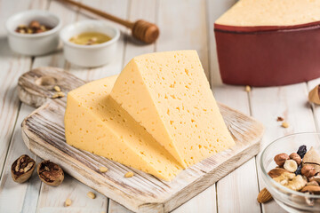 Traditional cream cheese cut into pieces on a wooden board.