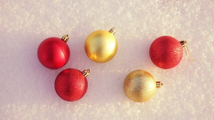 Christmas decorations. Red and gold Christmas ball on natural white snow.  New year winter concept. Top view, copy space, flat lay.