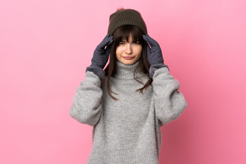 Teenager Ukrainian girl with winter hat isolated on white background unhappy and frustrated with something. Negative facial expression