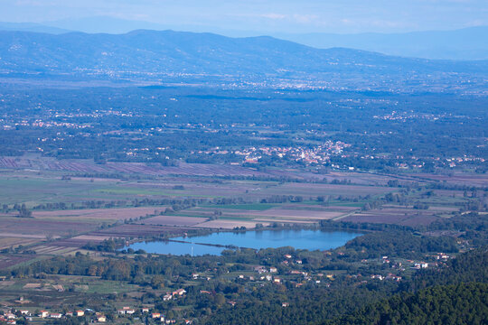 view from the top of the mountain to the city of Capannori , lake della Gherardesca and its surroundings in Italy in early autumn