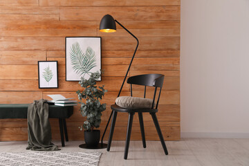 Stylish room interior with floor lamp, beautiful paintings and potted eucalyptus plant © New Africa