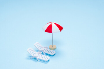 Travel concept. Sun lounger, red umbrella on a blue background.
