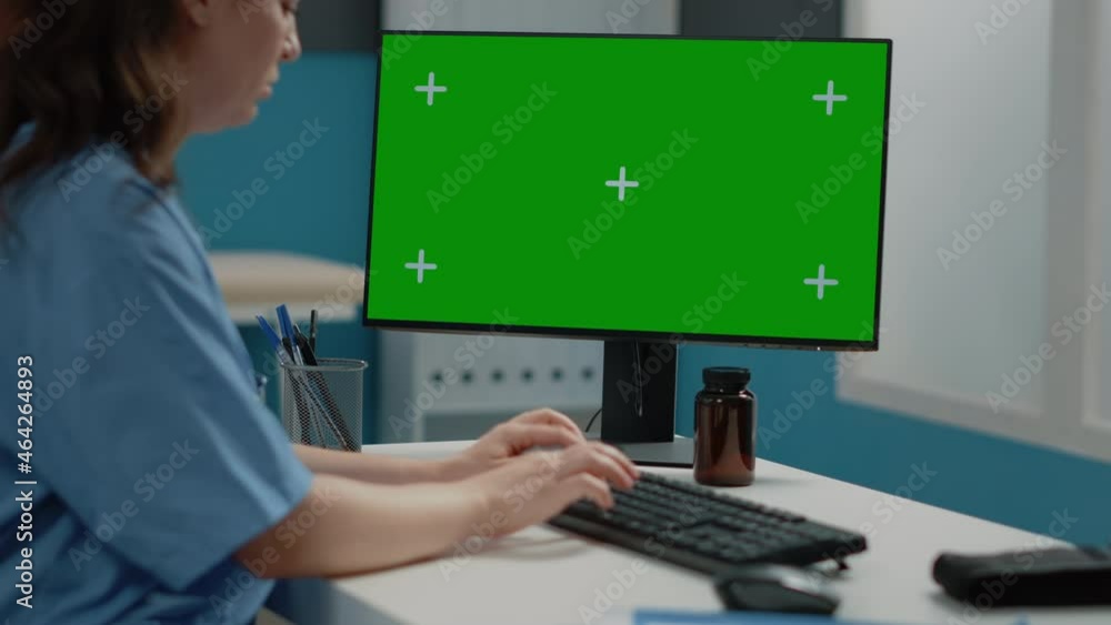 Poster close up of woman nurse looking at horizontal green screen on computer. medical assistant using tech