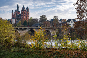 View towards the magnificent cathedral of Limburg an der Lahn / Germany in autumn and the old stone bridge over the Lahn 