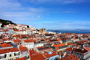 Fototapeta na wymiar Lisbon, Portugal - June, 2019: Panoramic view of the Lisbon rooftops and the Douro River from the observation deck of Santa Justa elevator.