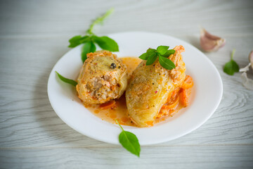stewed in gravy stuffed peppers in a plate on a wooden table