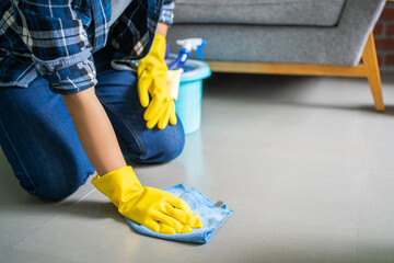 Woman with gloves cleans the floor close up.