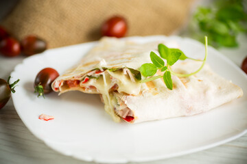 baked pita roll with filling in a plate on the table