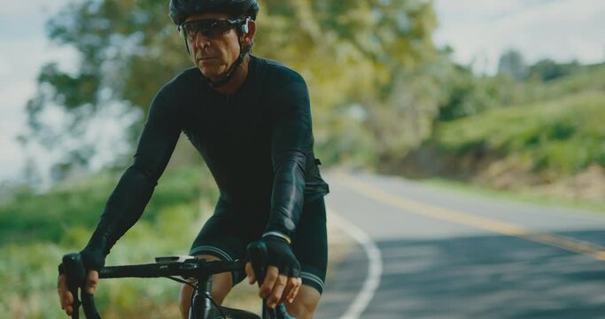 Cyclist riding bike on country road, athlete training intense workout active healthy lifestyle